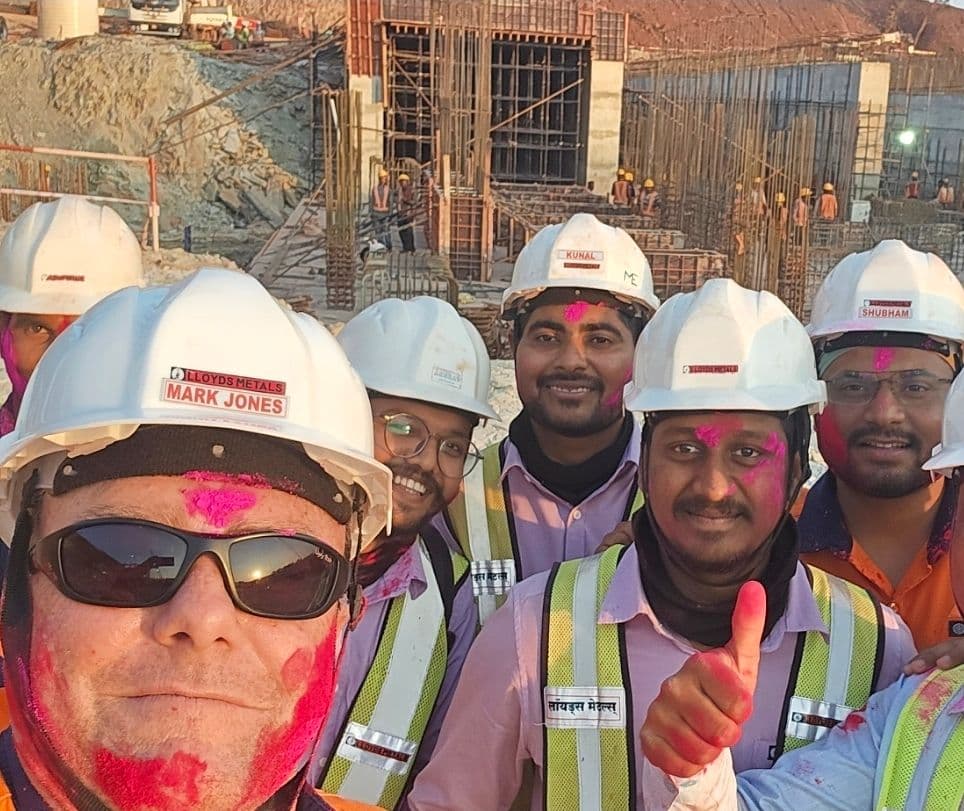 Mark Jones with members of the Lloyds Metals site team wearing hard hats and high-visibility vests.